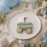 Bolacha de especiarias em formato de carrinho de bebê, decorada à mão com glacê real em verde sálvia e branco