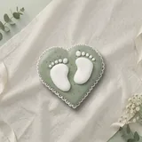 Bolacha de especiarias em formato de coração com pezinhos, decorada à mão com glacê real em verde sálvia e branco