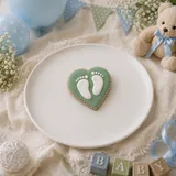 Bolacha de especiarias em formato de coração com pezinhos, decorada à mão com glacê real em verde sálvia e branco