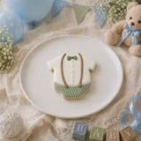 Bolacha de especiarias em formato de macacão, decorada à mão com glacê real em verde slávia