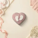 Bolacha de especiarias em formato de coração com pezinhos, decorada à mão com glacê real em rosê e branco