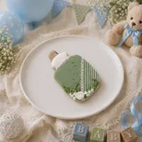 Bolacha de especiarias em formato de mamadeira, decorada à mão com glacê real em verde sálvia