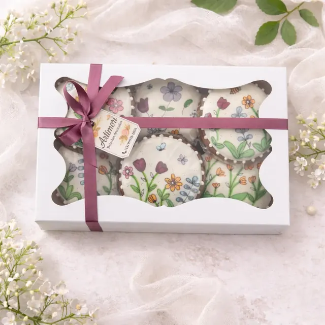 Uma caixa presenteável com 6 bolachas de especiarias decoradas à mão em glacê real branco, com ilustrações florais coloridas