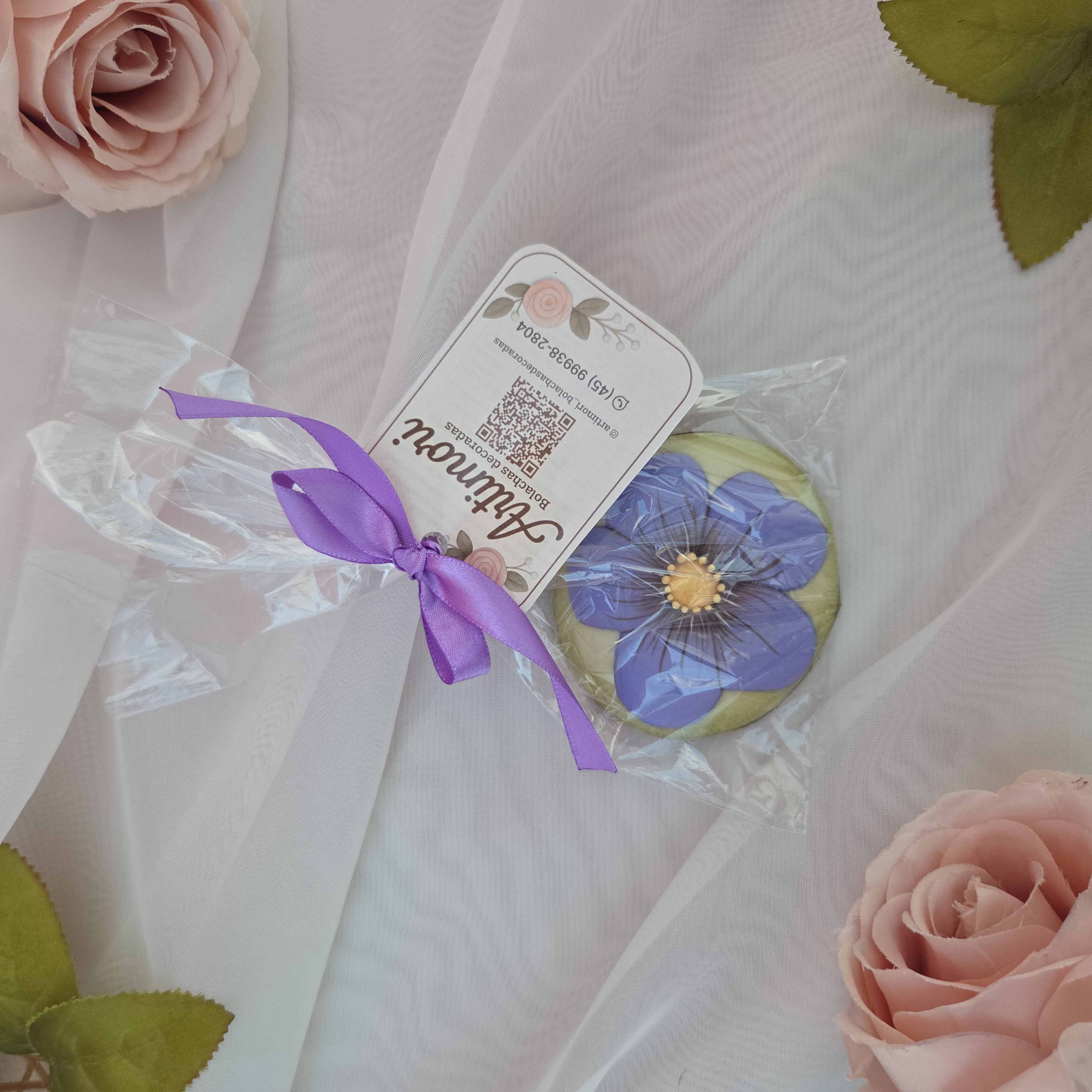 Bolacha artesanal de especiarias decorada à mão com glacê real em tema floral lilás.
